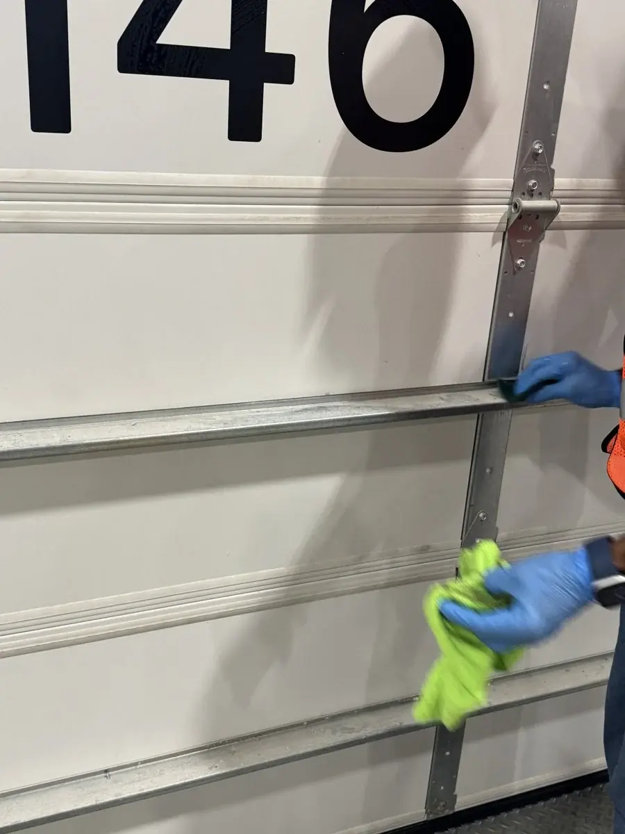 Gloved hands cleaning a commercial door.